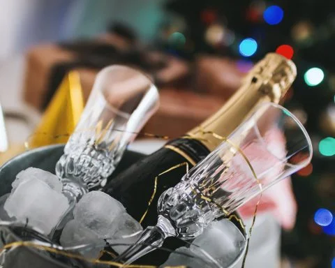 selective focus photography of brown labeled bottle and two clear glass champagne flutes